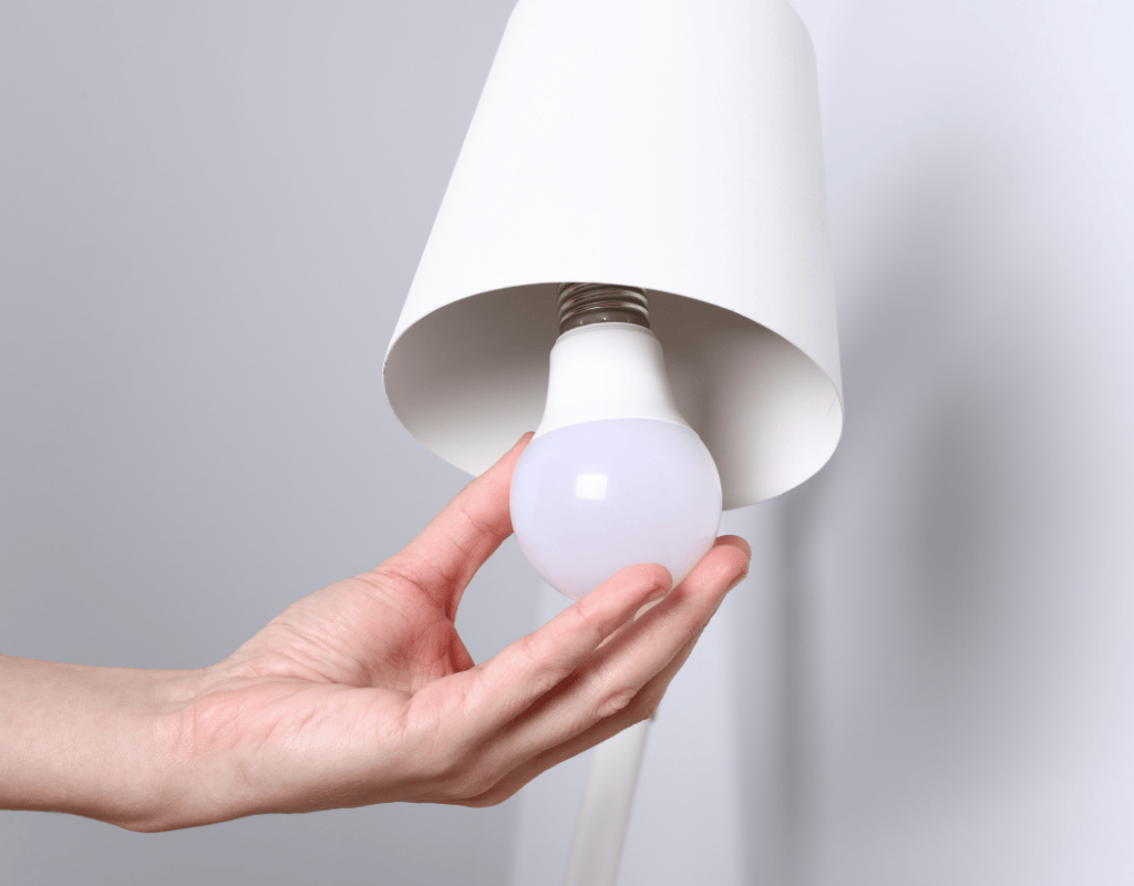 hand installing LED light bulb in modern lighting fixture Columbia MO