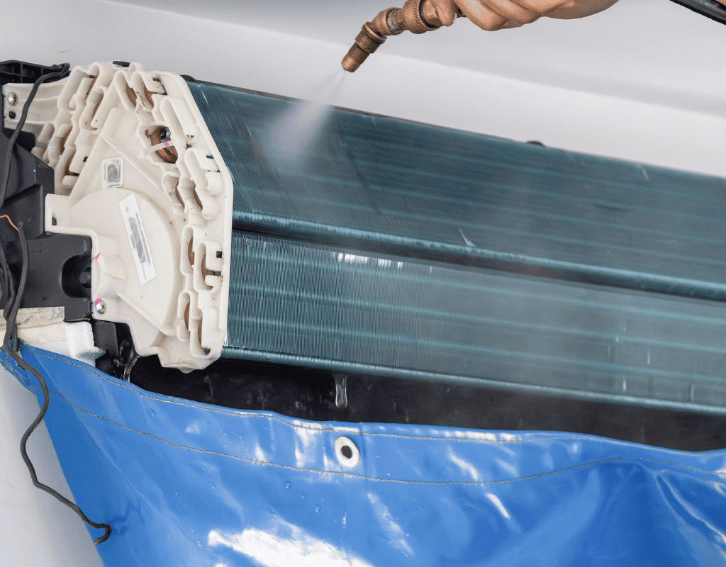 technician cleaning air conditioner coil during maintenance in Columbia MO