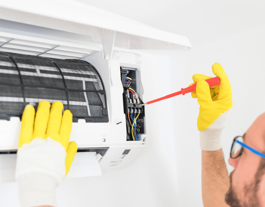 technician repairing indoor AC unit wiring and components in Columbia MO