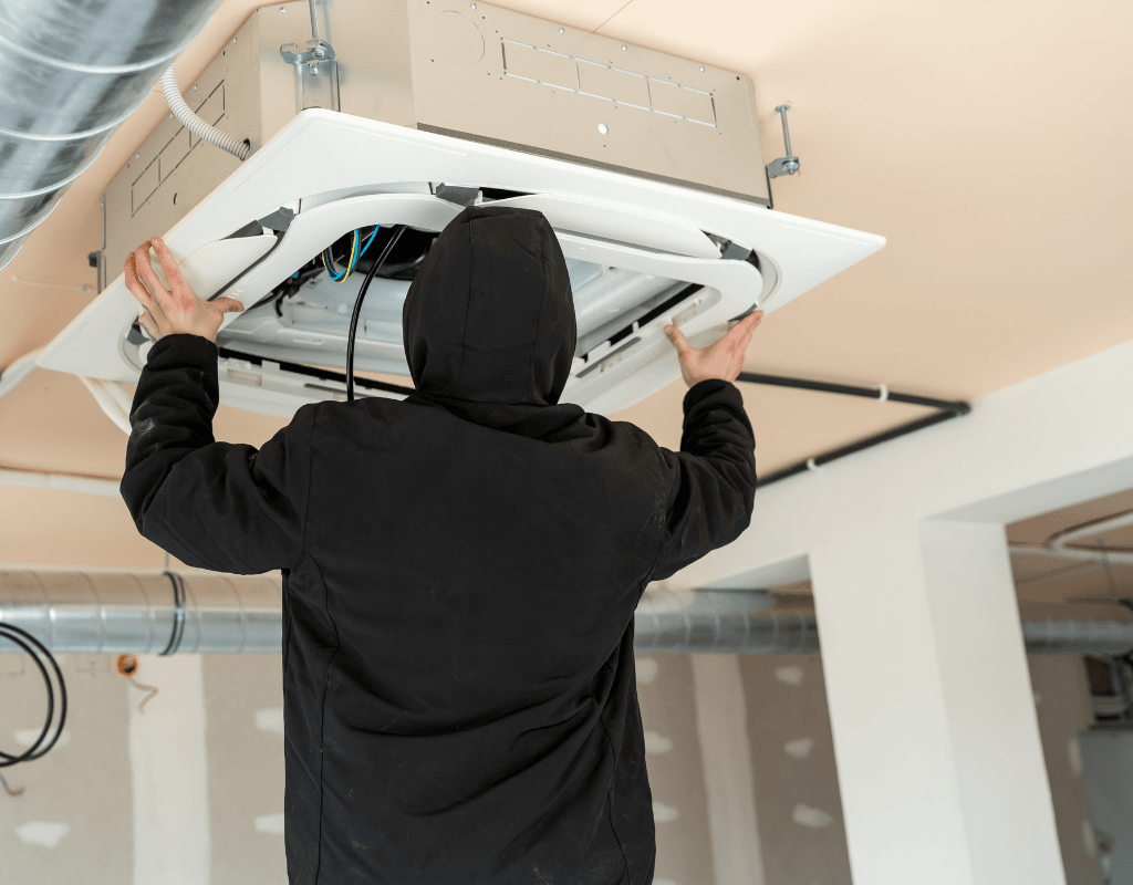 technician installing ceiling mounted commercial HVAC unit in Columbia MO
