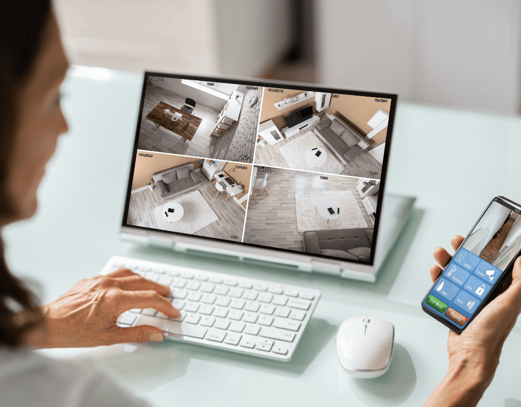 homeowner monitoring security cameras remotely on laptop and smartphone in Columbia MO