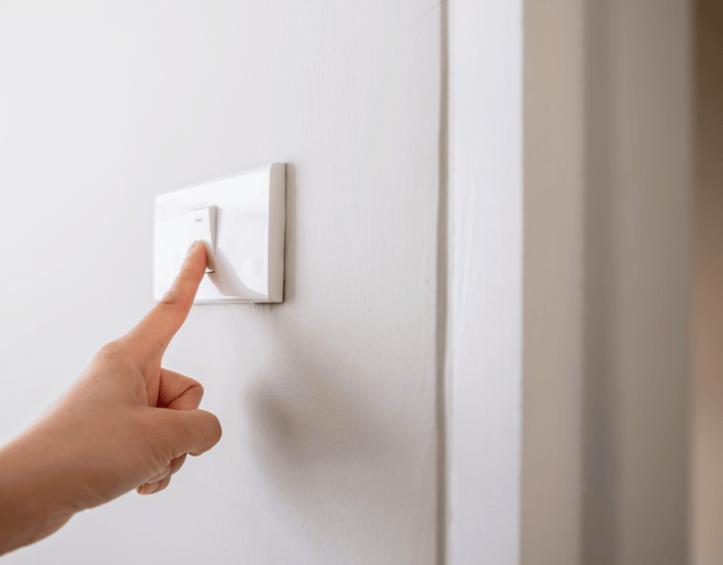 hand turning on wall light switch after installation in Columbia MO